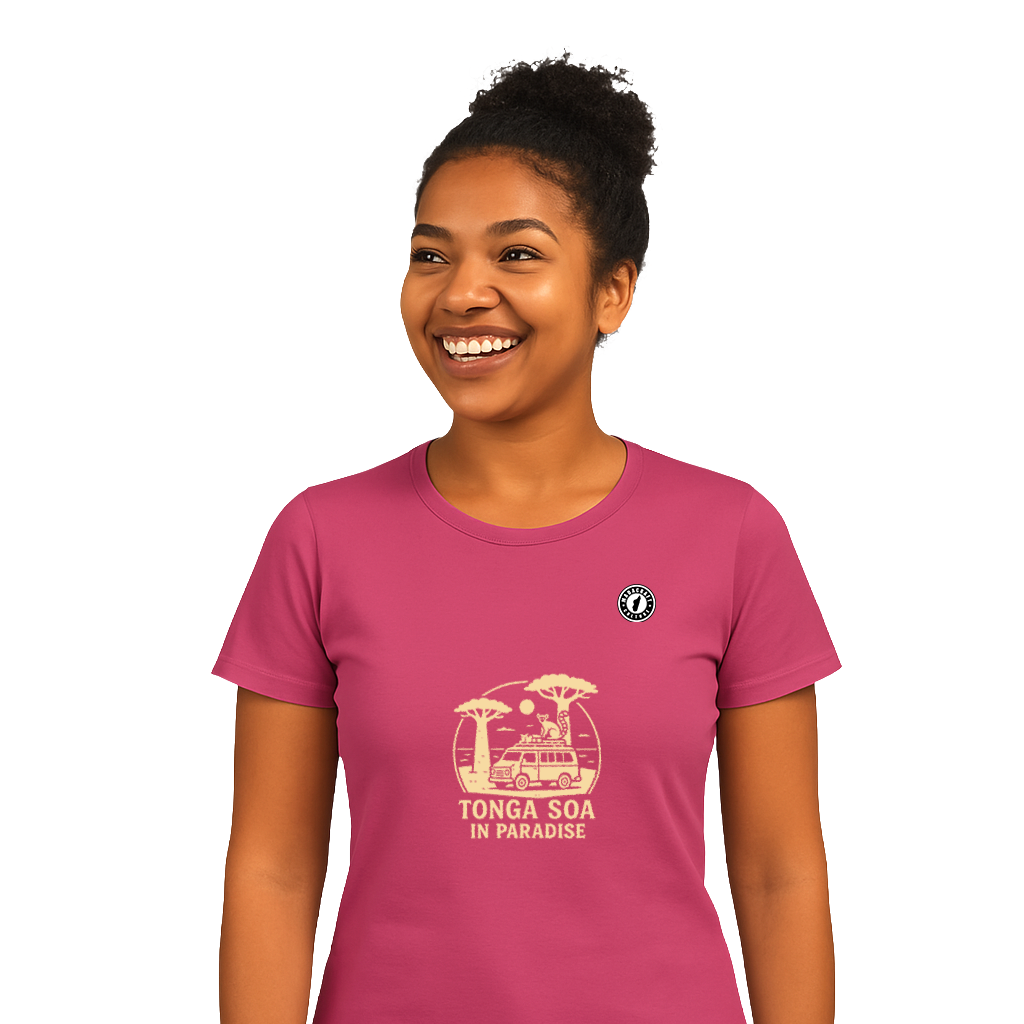 Jeune femme malgache souriante portant un t-shirt rose uni sur une plage ensoleillée, représentant la collection été 2025 de Madacraft Culture.